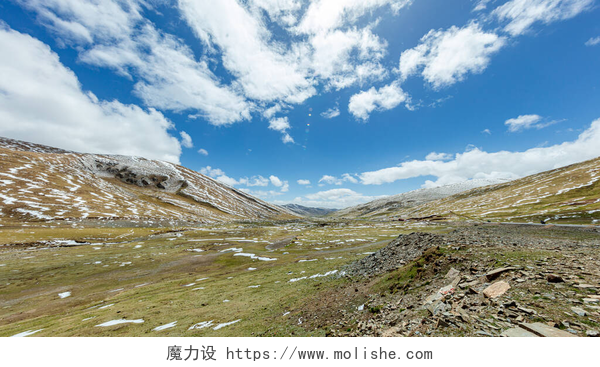 蓝天白云下的山区草原青海省的山区和草原是通过公路延伸的